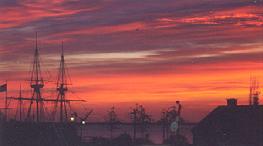 Dramatic sunrise over Plymouth Harbor with the Mayflower II silhouette